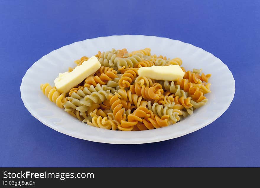 Colored noodle dish with pieces of butter. Colored noodle dish with pieces of butter