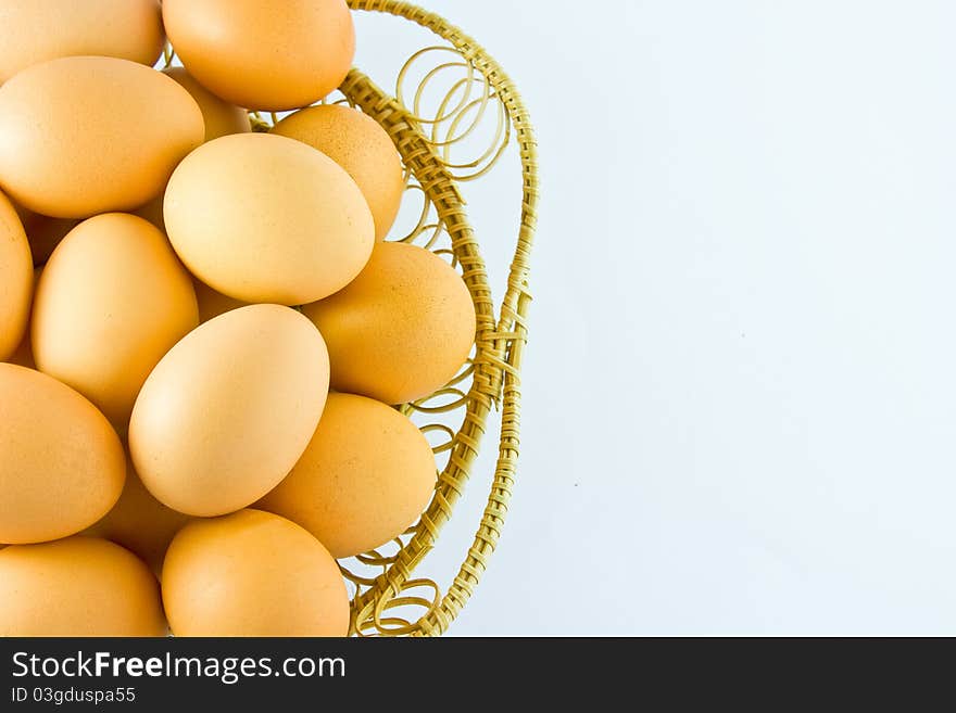 Chicken eggs in a basket on white background with right space