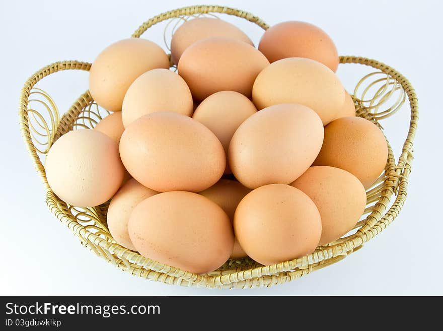 Chicken eggs in a basket on white background