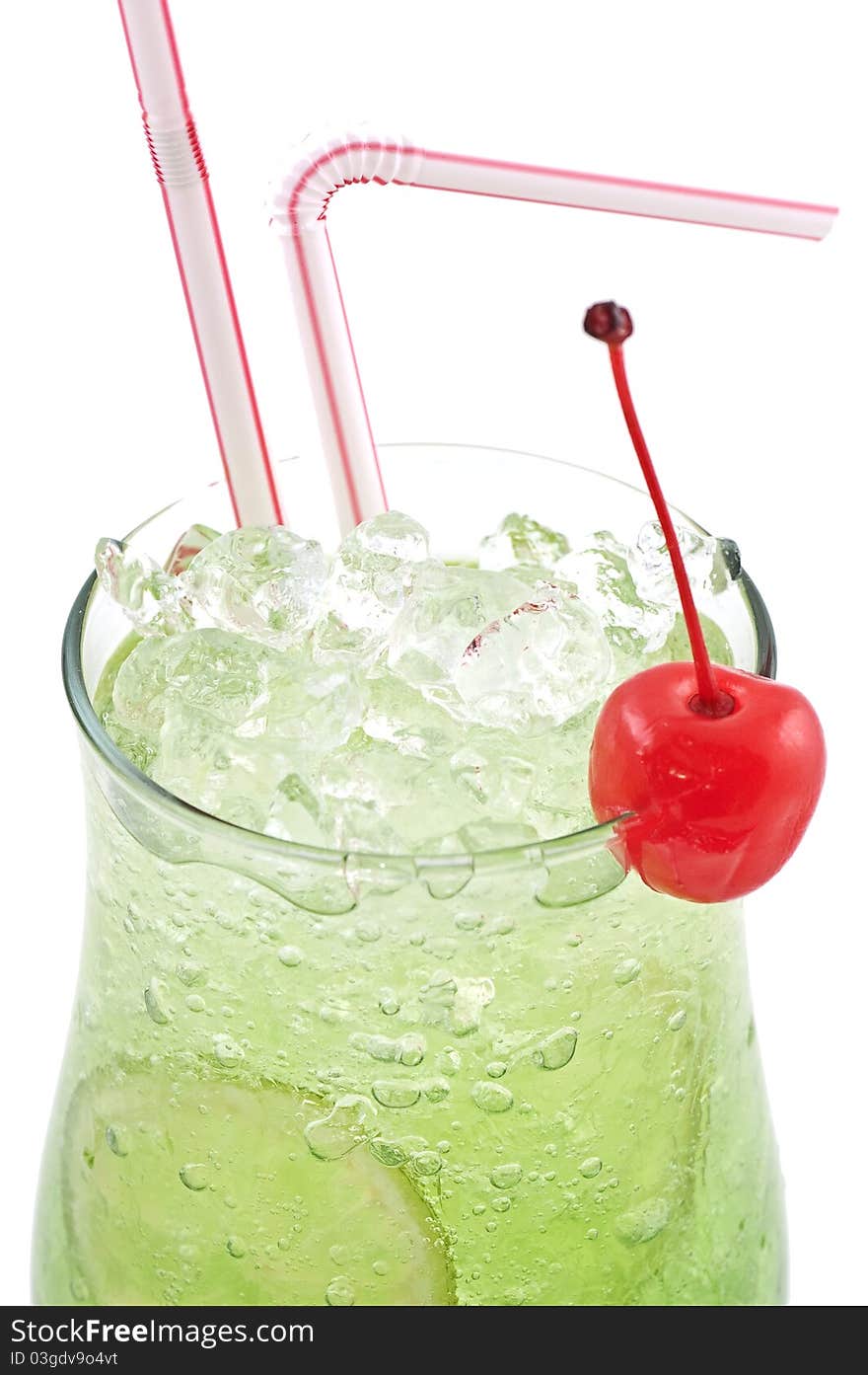 Green cocktail with a lemon and a cherry with ice and vials close up on a white background