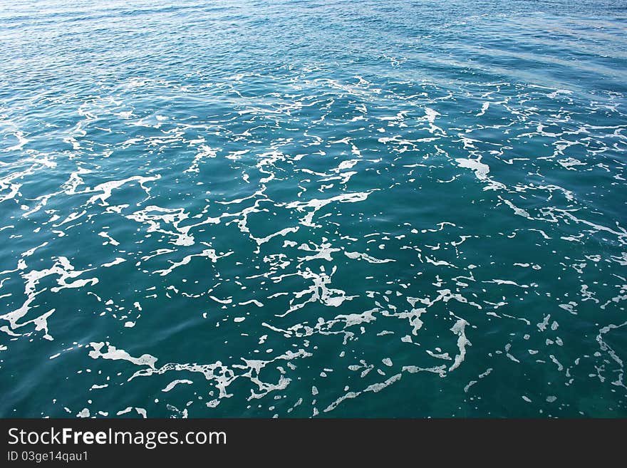 Blue sea surface with foam.