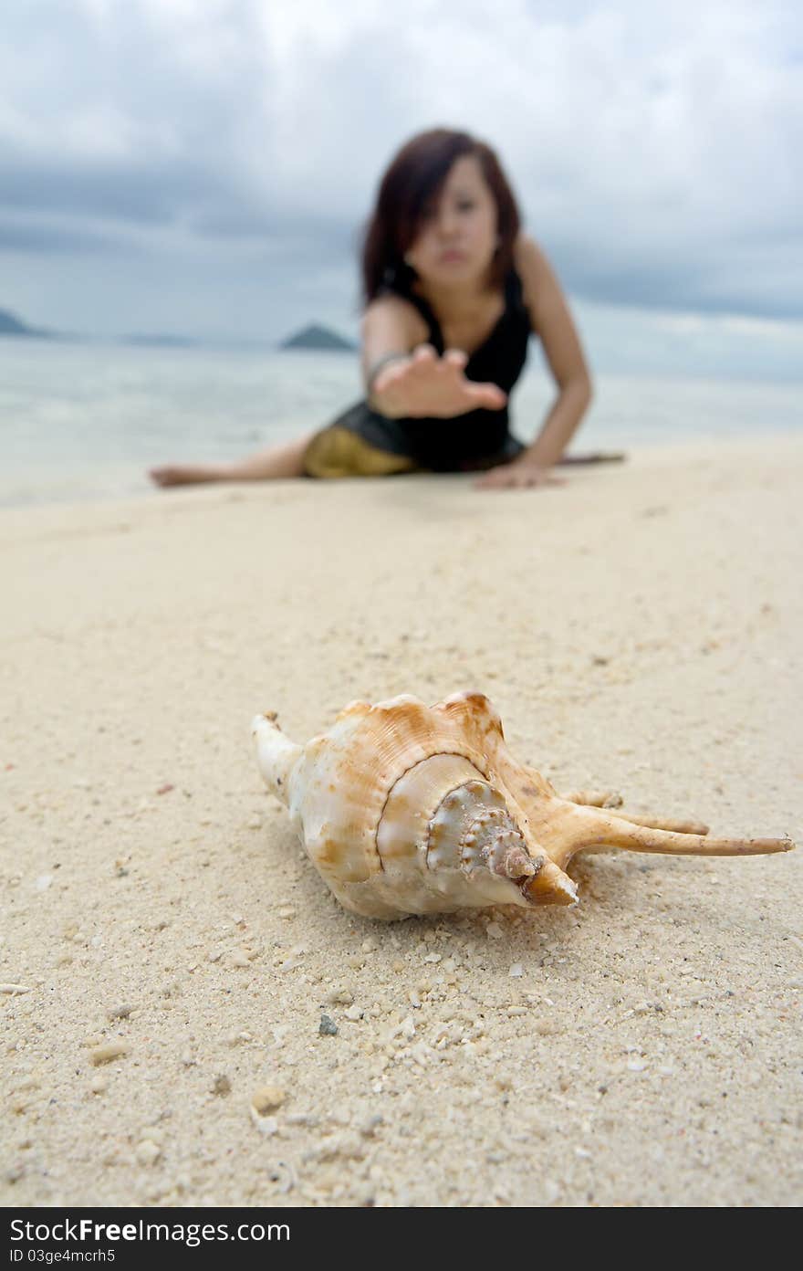 Photograph of a beautiful woman acting to grab the crab on beach during holiday. Photograph of a beautiful woman acting to grab the crab on beach during holiday