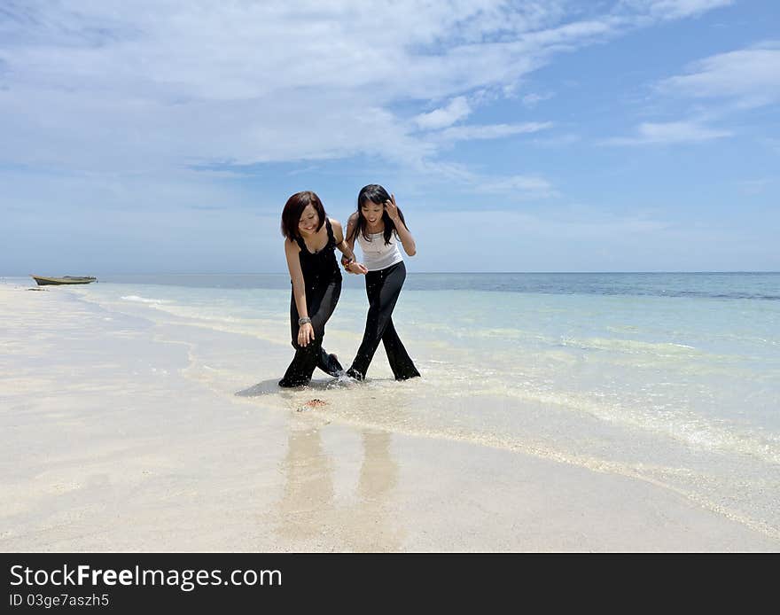 Friendship girlfriend having fun on the beach, enjoying their summer holiday together.