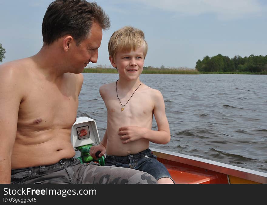 Two boatmen stearing a small boat over the lake. Two boatmen stearing a small boat over the lake