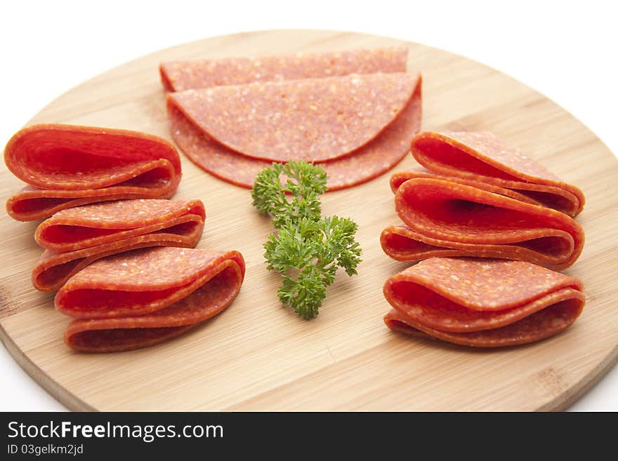 Paprika salami with parsley onto wood plates. Paprika salami with parsley onto wood plates