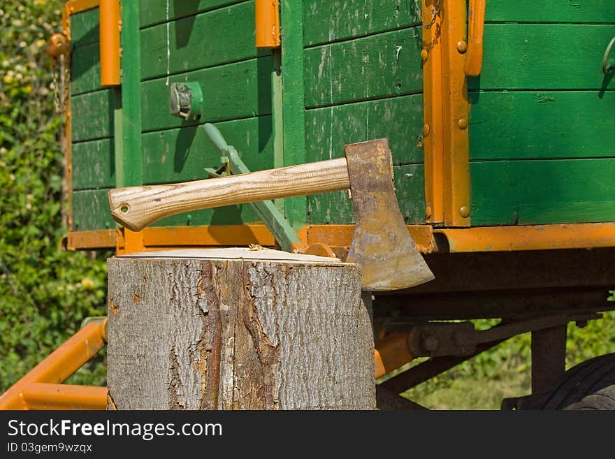 A trailer load with wood, before it an axe in log