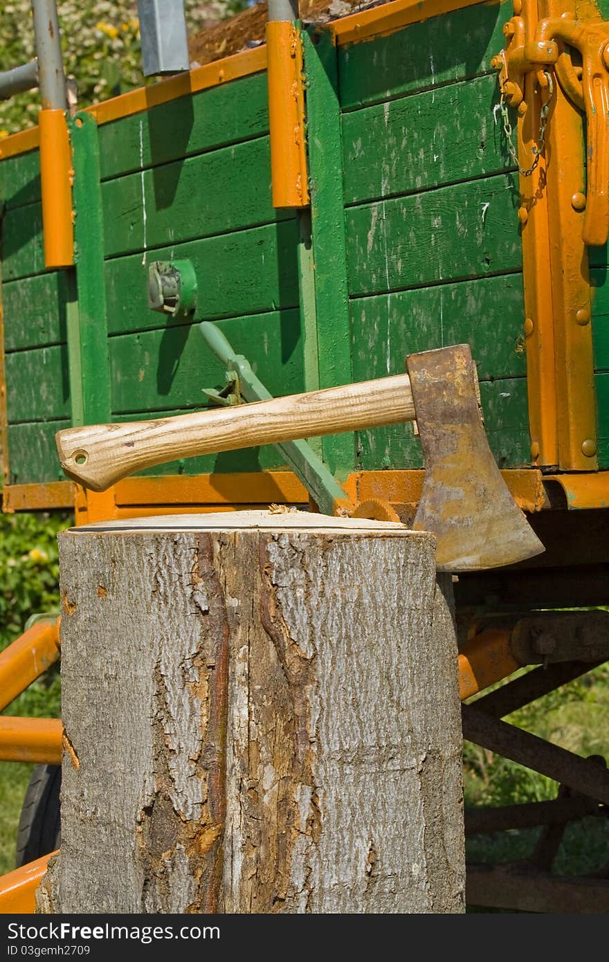 A trailer load with wood, before it an axe in log