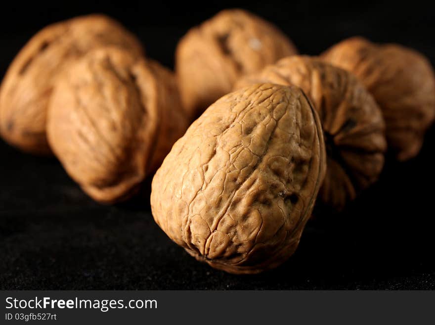 Some beautiful wallnuts in front of a black background