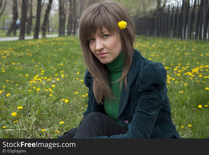 Young girl in a park sitting on grass. Young girl in a park sitting on grass