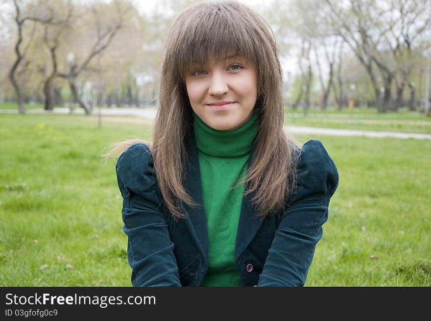 Young girl in a park sitting on grass. Young girl in a park sitting on grass