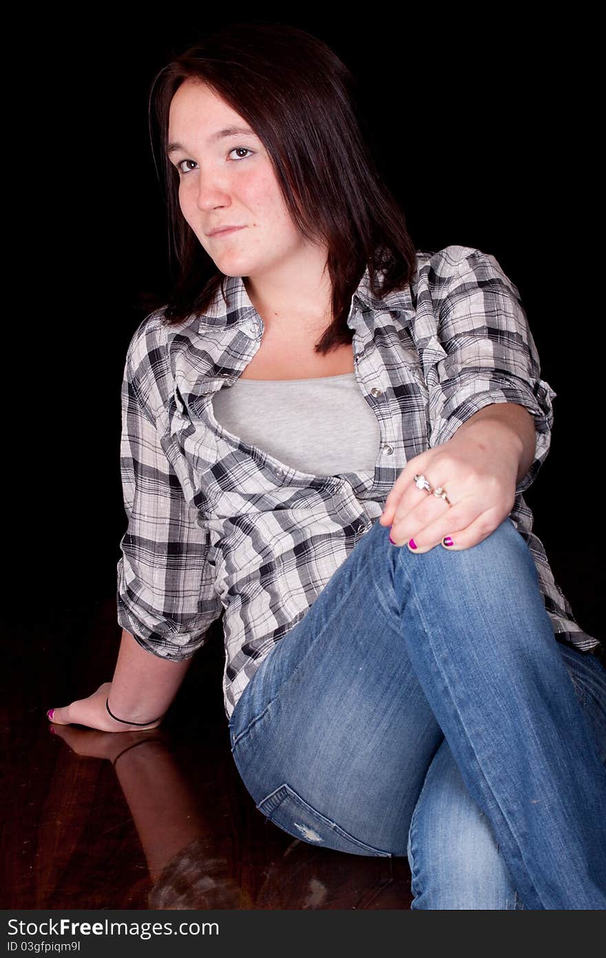 A photograph of a girl sitting on wood with her legs crossed thinking. A photograph of a girl sitting on wood with her legs crossed thinking.