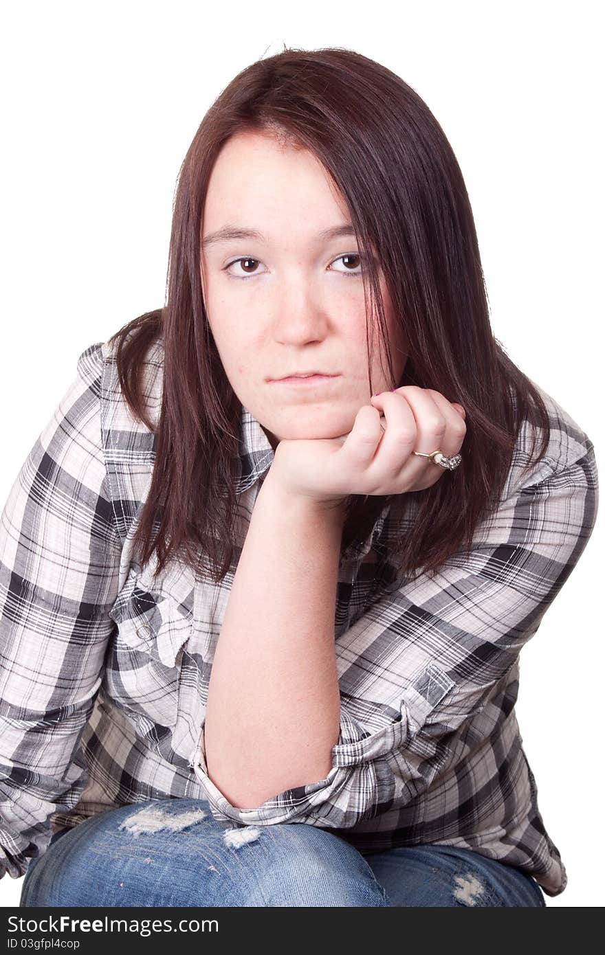 A photograph of a girl isolated sitting with her legs crossed and her hand under her chin. A photograph of a girl isolated sitting with her legs crossed and her hand under her chin.