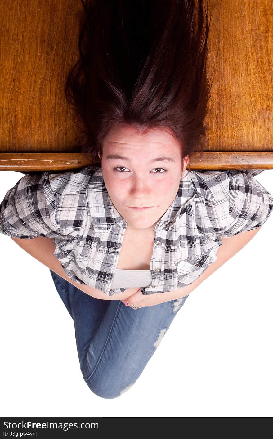 A photograph of a teenage girl upside down with her hair floating.