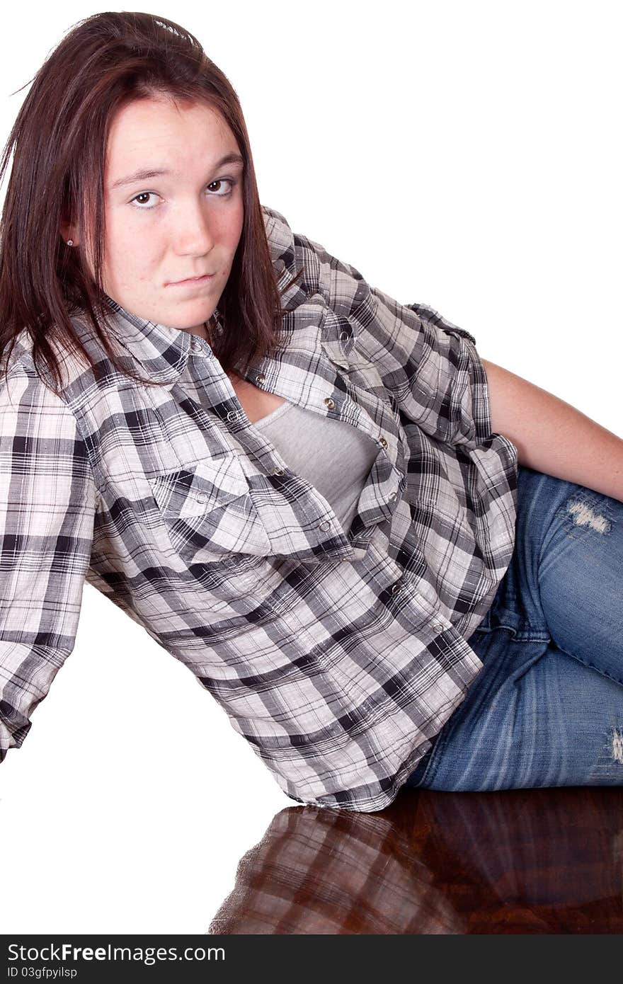 A photograph of a teenage girl sitting sideways on a wood desk thinking. A photograph of a teenage girl sitting sideways on a wood desk thinking.