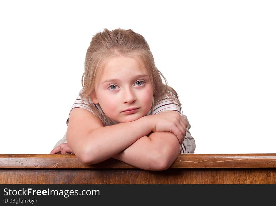 A photograph of a young girl lying on top a desk looking a little sad. A photograph of a young girl lying on top a desk looking a little sad.