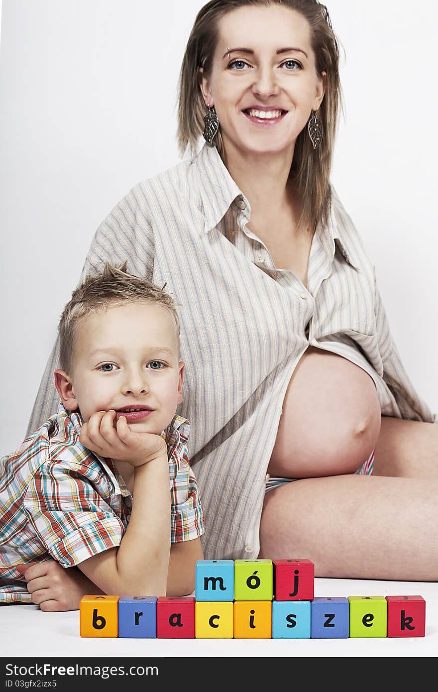 Pregnant mum and her son with colorful wooden blocks. Pregnant mum and her son with colorful wooden blocks