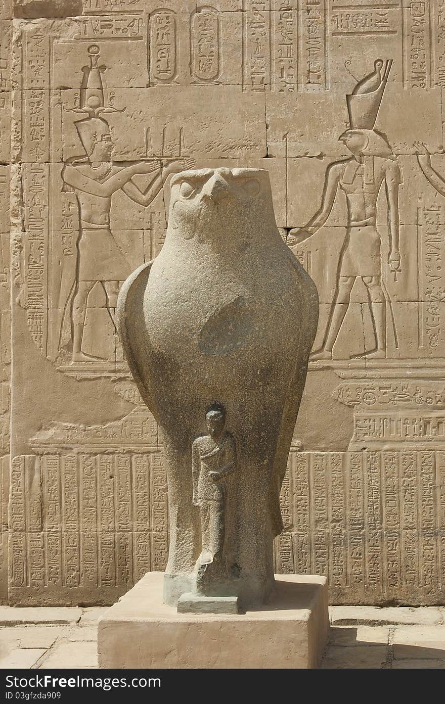 Large statue of the falcon god with hieroglyphics on wall at Edfu Temple. Large statue of the falcon god with hieroglyphics on wall at Edfu Temple