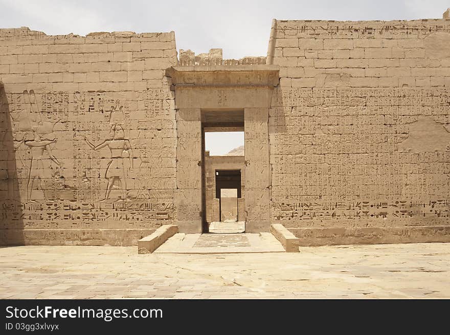 Egyptian hieroglyphic carvings on a wall at the Temple of Medinat Habu. Egyptian hieroglyphic carvings on a wall at the Temple of Medinat Habu