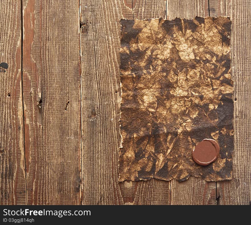 Old paper with a wax seal on brown wood texture with natural patterns