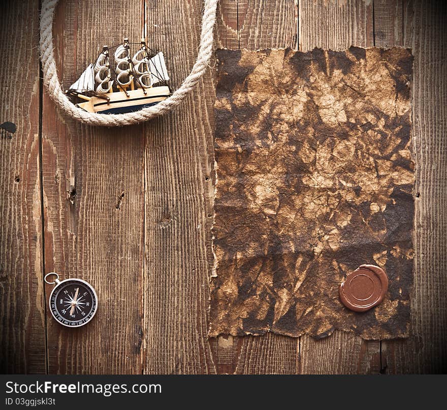 Old paper, rope and model classic boat on wood background