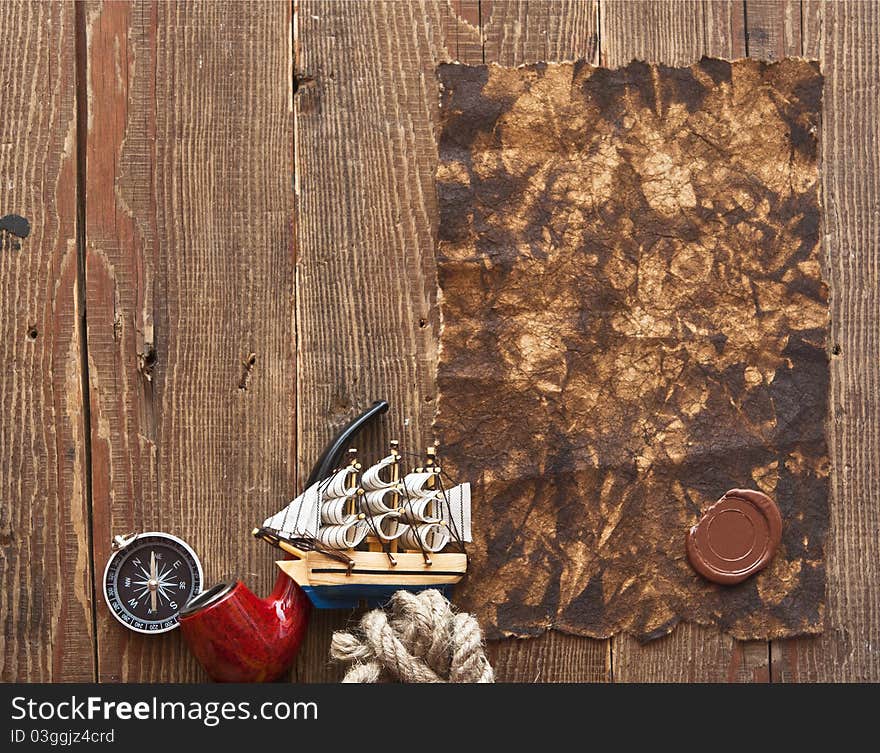 Old paper, rope and model classic boat on wood background