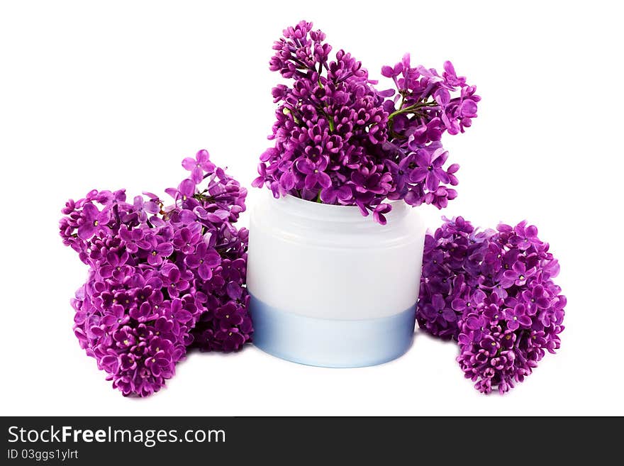 Jar of cream and lilac flowers around isolated on white background. Jar of cream and lilac flowers around isolated on white background