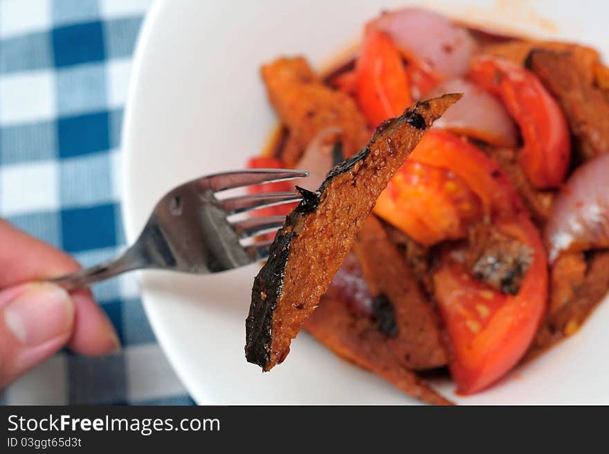 Fork picking up meat slice