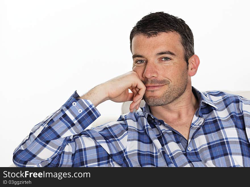 Beautiful young man smiling on sofa. Beautiful young man smiling on sofa