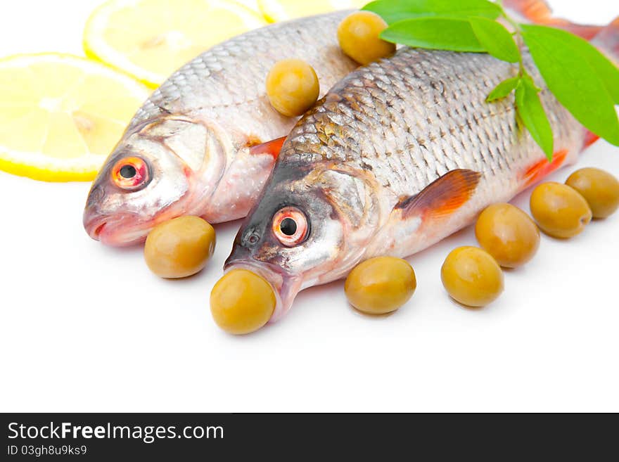 Cooking two fish redeyes with olives, isolated on a white background. Cooking two fish redeyes with olives, isolated on a white background