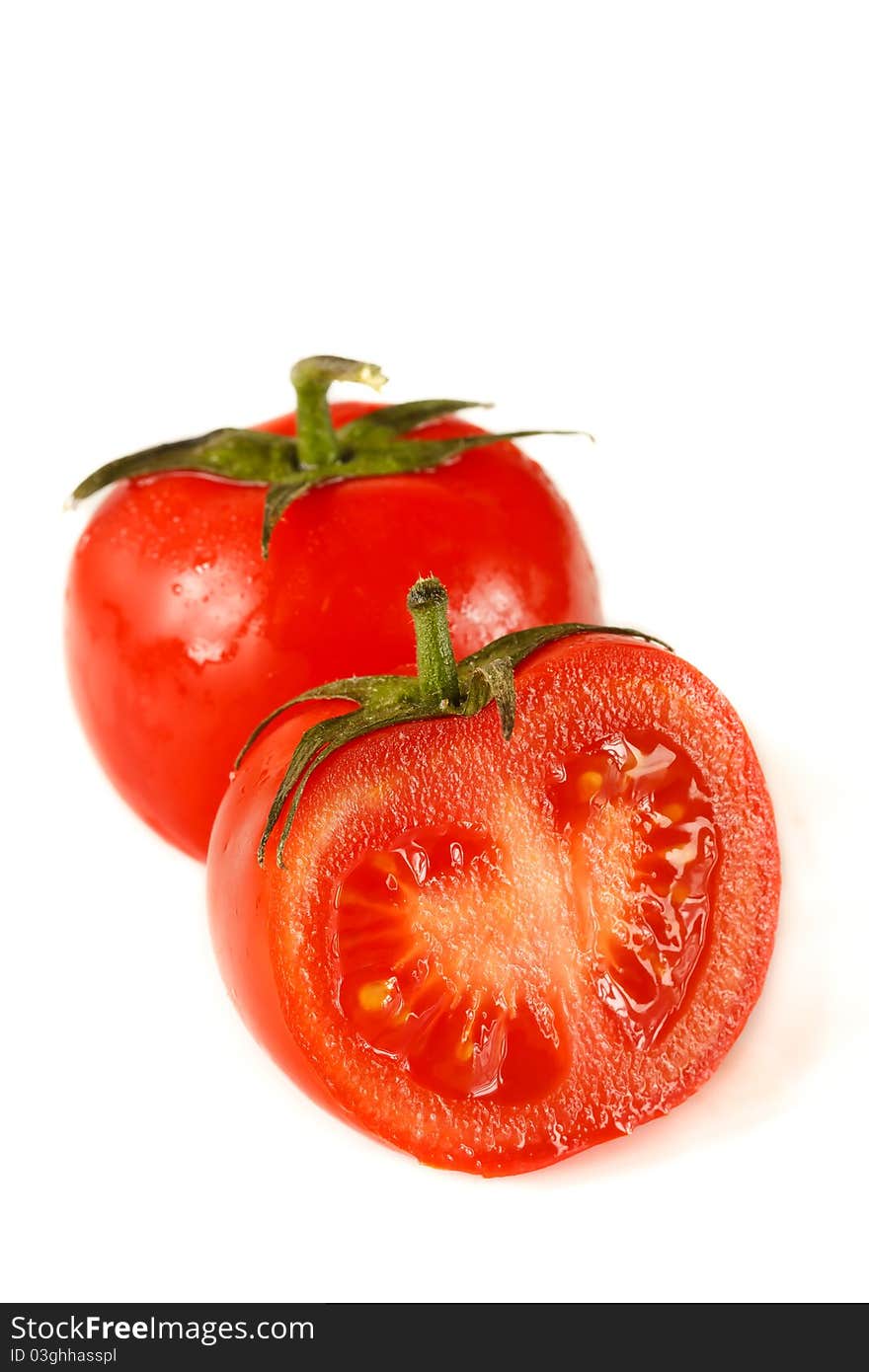 Fresh garden tomatoes with water drops on a white. Fresh garden tomatoes with water drops on a white.