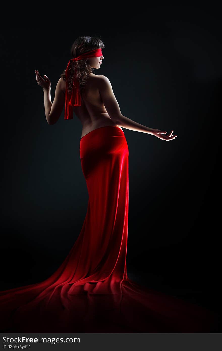 The girl in a red dress against a dark background