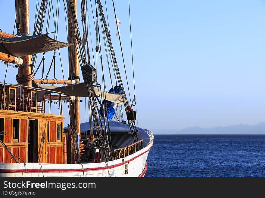 Sailing ship floating by sea and mountain in a fog before it. Sailing ship floating by sea and mountain in a fog before it