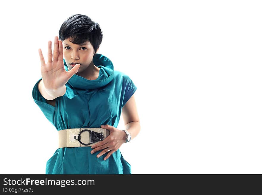 A women in green suite shows stop sign with his right hand with serious face and isolated with white background. A women in green suite shows stop sign with his right hand with serious face and isolated with white background.