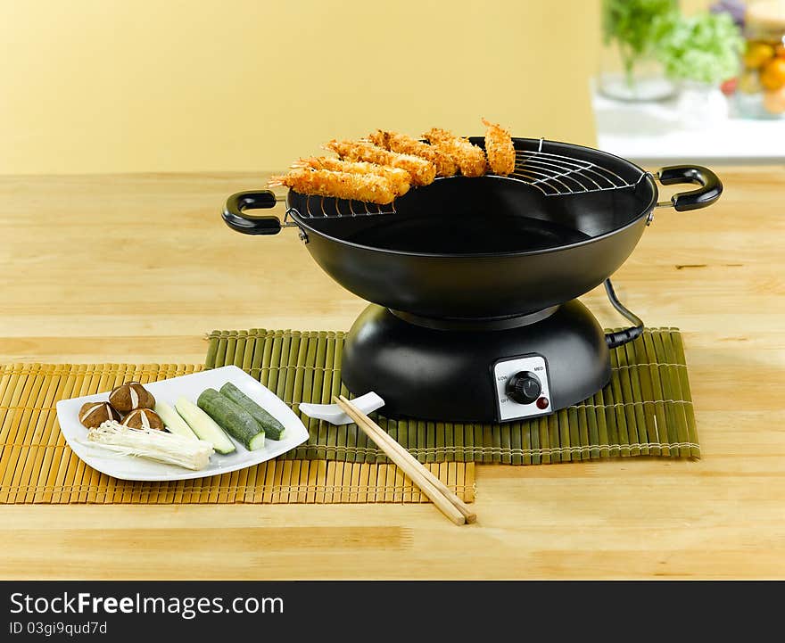 Fried shrimps tempura with electric pan an image isolated in the kitchen interior