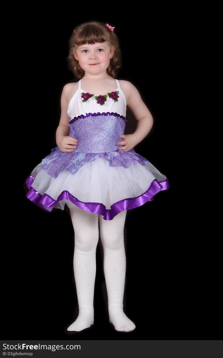 Adorable little girl standing proudly in her ballet outfit. Isolated on black. Adorable little girl standing proudly in her ballet outfit. Isolated on black