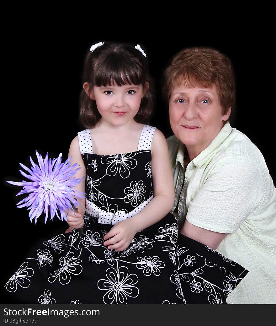 Grandmother and young granddaughter smiling.