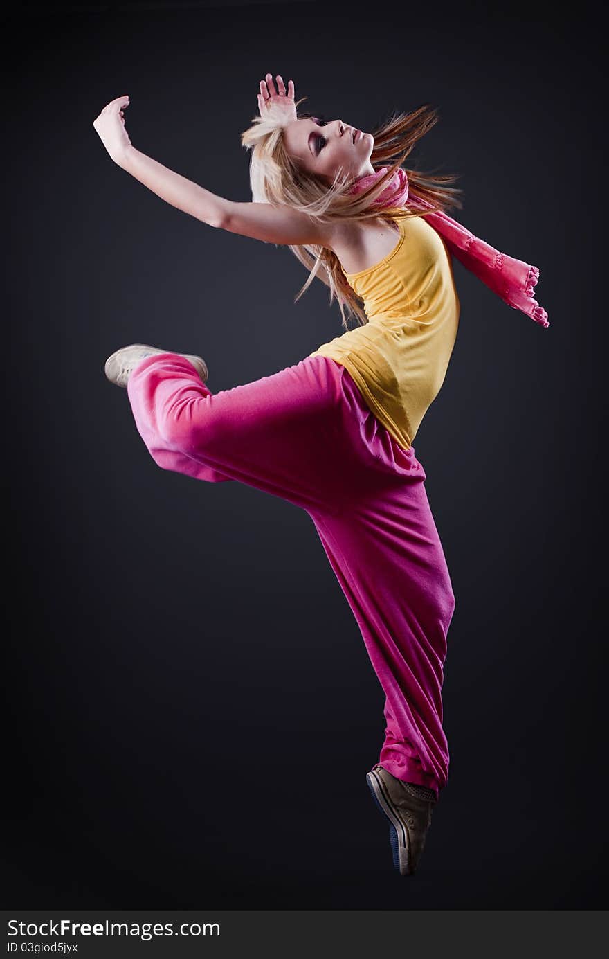 Full-length portrait of a woman dancing on a dark studio background. Full-length portrait of a woman dancing on a dark studio background