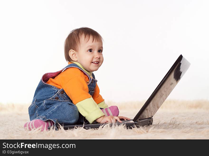 Picture of a baby with laptop on a white. Picture of a baby with laptop on a white