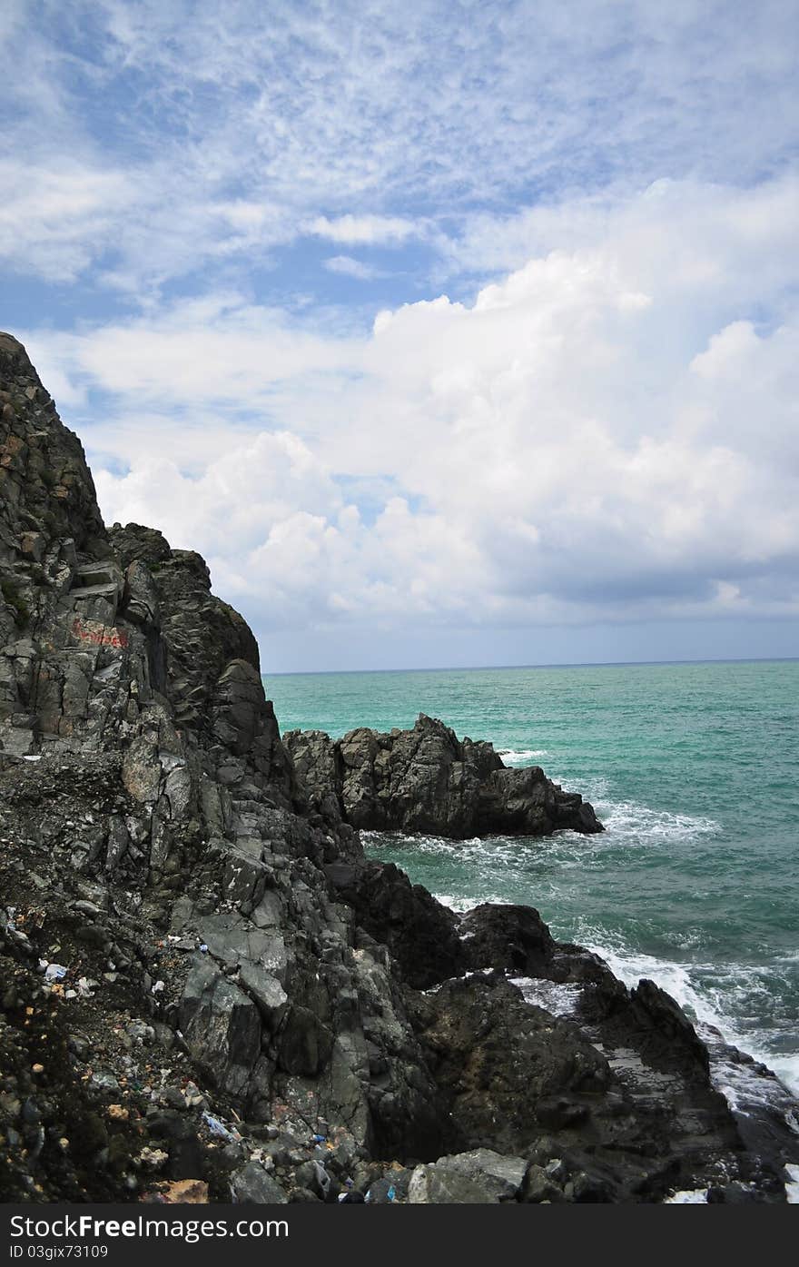 Cliff , blue sea and white clouds