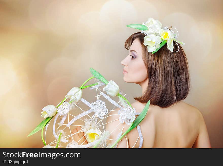 The beautiful girl with a flower on a head and a bouquet