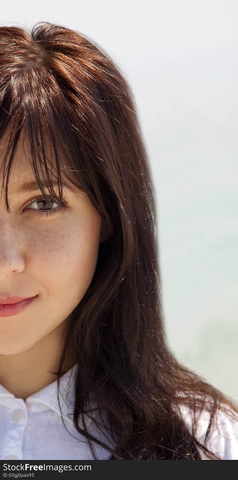 Half face portrait of brunette girl. Outdoor photo. Half face portrait of brunette girl. Outdoor photo.