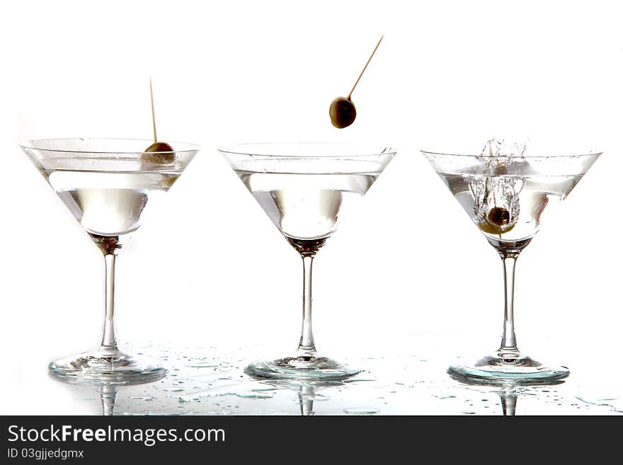 3 cocktail glasses and 3 falling olives. 3 cocktail glasses and 3 falling olives