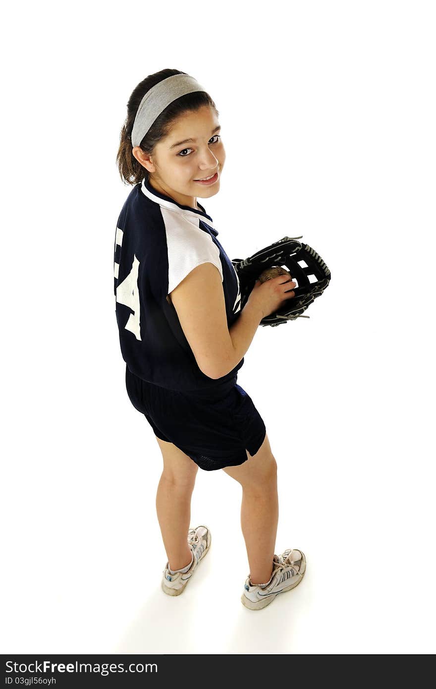 An attractive young teen happily sitting on an old bench wearing her team's softball uniform. She holds a new mitt and a well worn ball. An attractive young teen happily sitting on an old bench wearing her team's softball uniform. She holds a new mitt and a well worn ball.