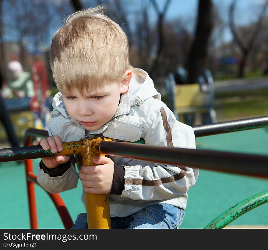 Young boy walks in the park among the trees. Spring mood