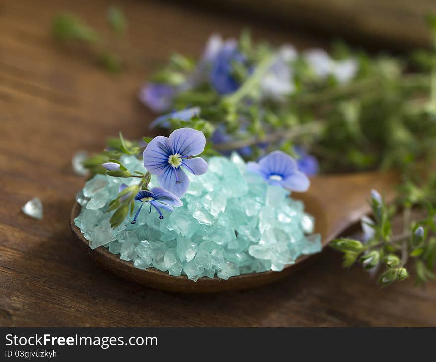 With blue bathing salt over wooden background. With blue bathing salt over wooden background