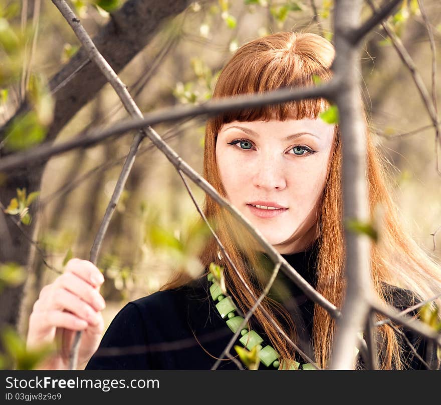 The beautiful woman among a spring leafs