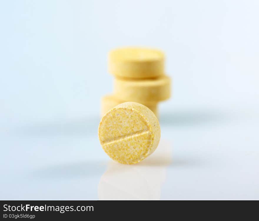 Isolated yellow pills on white