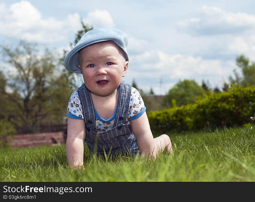 In a cap crawling on the grass. In a cap crawling on the grass