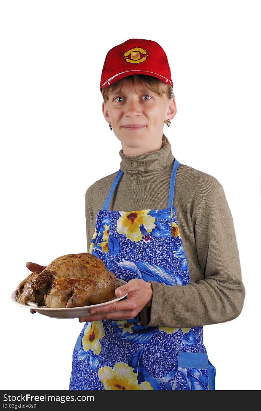 The young woman holds a plate with a roast chicken. The young woman holds a plate with a roast chicken.