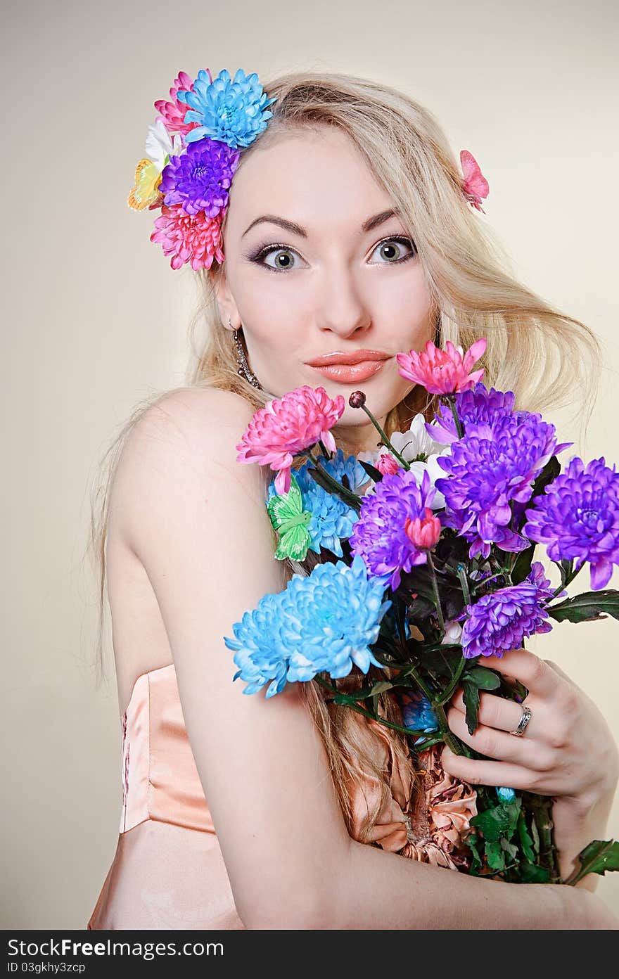 Beautiful young woman with colorful flowers in hair